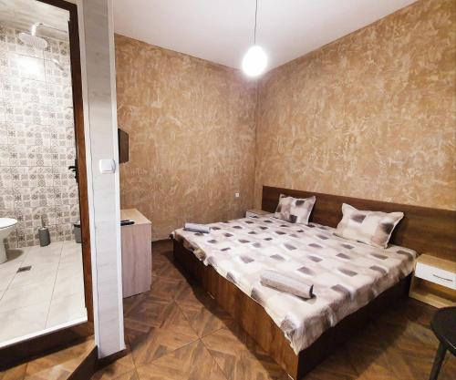 a bedroom with a large bed and a bathroom at Студио Теа in Sliven