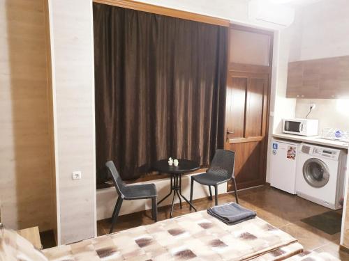a small room with a table and chairs and a microwave at Студио Теа in Sliven