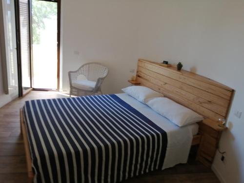 - une chambre avec un lit et une tête de lit en bois dans l'établissement Il Silos, à Maccarese