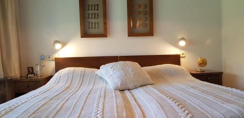 a bedroom with a white bed with two pillows on it at Káli Art Inn in Köveskál