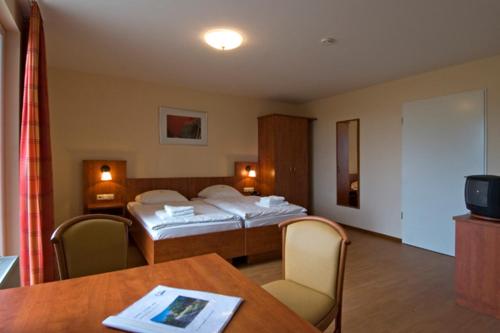 a hotel room with two beds and a table at Ferienstätte und Seminarhaus Theodor-Schwartz Travemünde in Lübeck