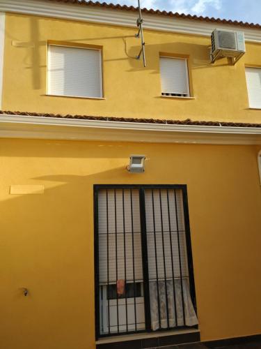 a yellow building with a gate in front of it at Beautiful House Sierrecilla in Humilladero