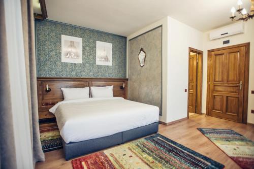 a bedroom with a white bed and a wooden headboard at Pensiunea Kant in Sibiu