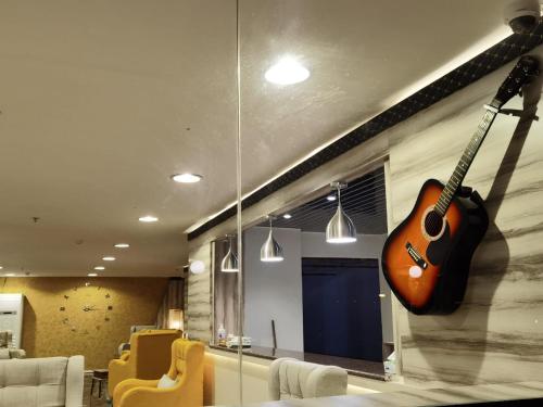 a guitar hanging on a wall in a living room at فندق الحاتمية in Abha