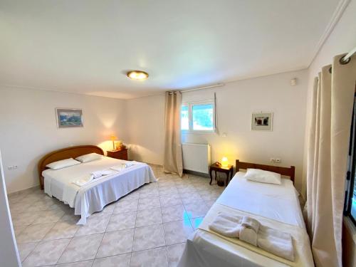 a bedroom with two beds and a room with two tables at Villa Aegean in Mourteri