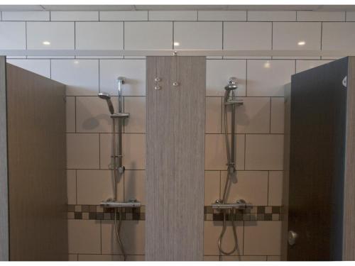y baño con 2 puestos con ducha y espejos. en Prime Backpackers Angel en Londres
