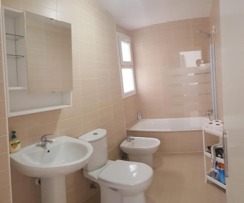 La salle de bains est pourvue de toilettes, d'un lavabo et d'une baignoire. dans l'établissement Stylish apartment in Portofino, near the beach and bars, à Almerimar