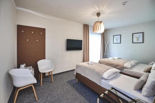 a hotel room with two beds and a tv at Apart Nova - pokoje gościnne in Szczyrk