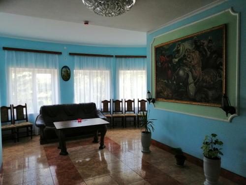 - un salon avec un piano et un tableau mural dans l'établissement West Fort, à Zolochiv