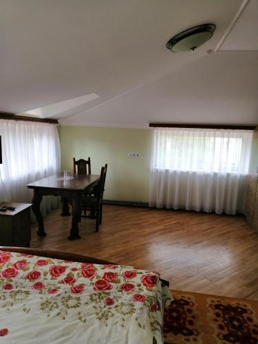 Zimmer mit einem Tisch und einem Bett mit Rosen in der Unterkunft West Fort in Zolochiv