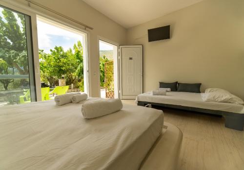 a bedroom with two beds and a large window at Kanali Village Parga in Parga