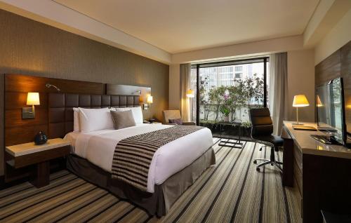 een hotelkamer met een groot bed en een bureau bij JW Marriott Hotel Mexico City Santa Fe in Mexico-Stad