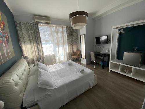 a bedroom with a white bed and a couch at Corso Italia Rooms in Milan