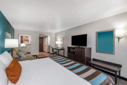 a hotel room with a bed and a flat screen tv at Wingate by Wyndham - St. George in St. George