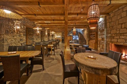 a restaurant with tables and chairs and a fireplace at Hotel Deutsche Muehle Bolnisi in Bolnisi