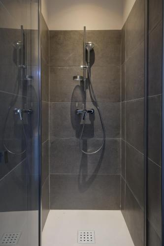 une douche avec une porte vitrée dans une salle de bain dans l'établissement La Maison Ryokufu, à Châteauneuf-du-Pape