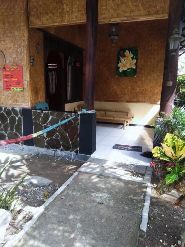un bâtiment avec un banc devant un bâtiment dans l'établissement Pondok Pusaka Alam 2 Pangandaran, à Pangandaran
