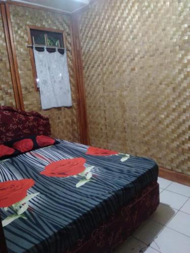 um quarto com uma cama com flores em Pondok Pusaka Alam 2 Pangandaran em Pangandaran