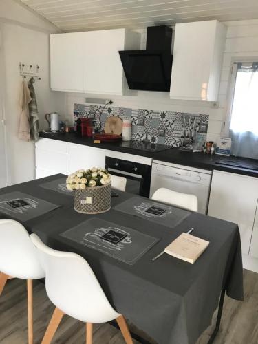 a kitchen with a table with a black table cloth at La cabane et sa cascade in Lège-Cap-Ferret