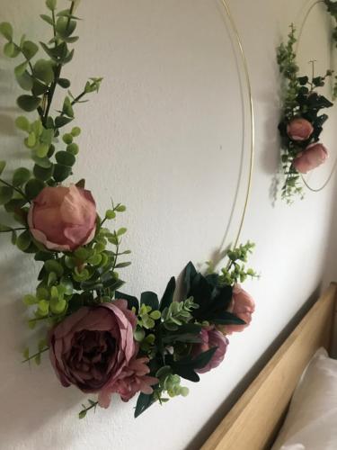 a mirror on a wall with flowers and roses at Kranach 5 - Wohnen beim Wein in Gamlitz