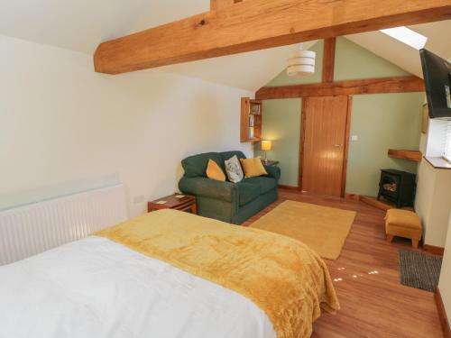 1 dormitorio con 1 cama y 1 silla en una habitación en Yeoman's Cottage, en Pickering