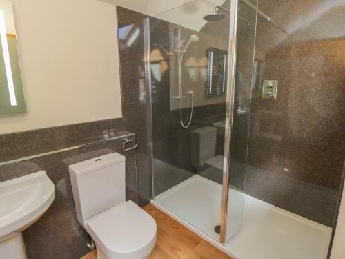 ein Badezimmer mit Toilette und Glasdusche in der Unterkunft Yeoman's Cottage in Pickering