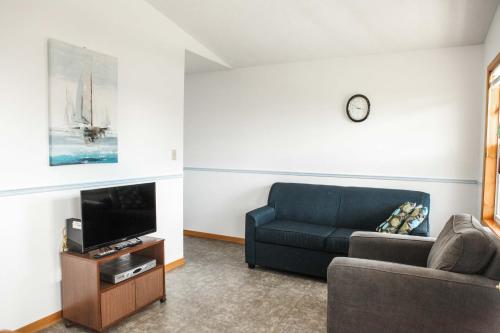 a living room with a couch and a tv at Peck's Housekeeping Cottages in Louisbourg