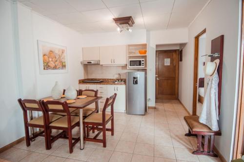 a kitchen and dining room with a table and chairs at La Sabana Hotel Suites Apartments in San José