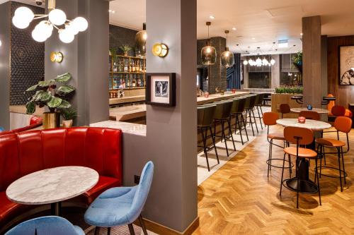 un restaurant avec des tables et des chaises ainsi qu'un bar dans l'établissement ibis Styles Edinburgh St Andrew Square, à Édimbourg