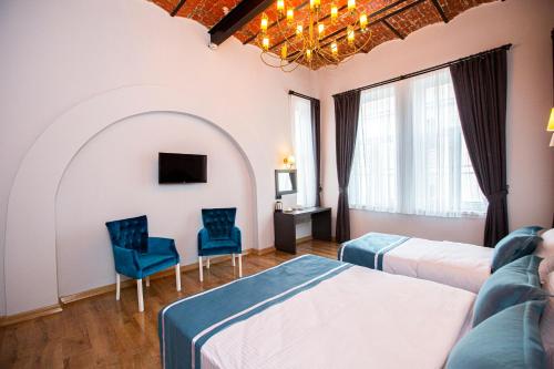 a hotel room with two beds and two chairs at The Independent Hotel Taksim in Istanbul
