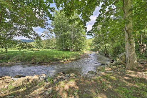 a stream in a field with trees at Quaint Creston Hideaway with Mtn Views and Hot Tub! in Creston