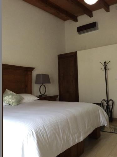 a bedroom with a large white bed in a room at Hotel Concierge Flor y Canto in Tepoztlán