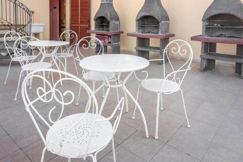 a group of white tables and chairs in front of a stove at Residence Le Fontane in Villasimius