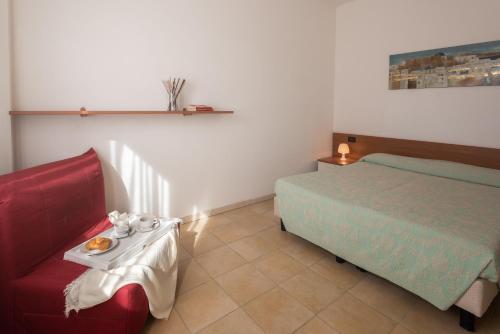 a bedroom with a bed and a table with a tray of food at Residence Le Fontane in Villasimius