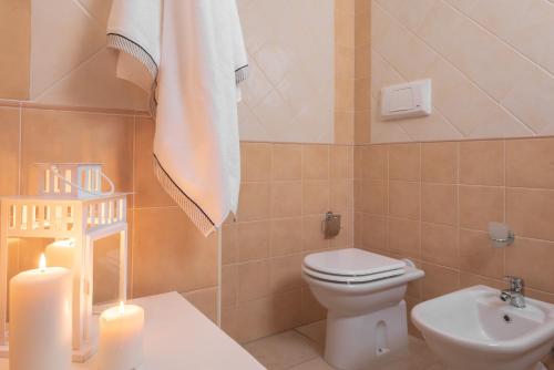 a bathroom with a toilet and a sink and a towel at Residence Le Fontane in Villasimius