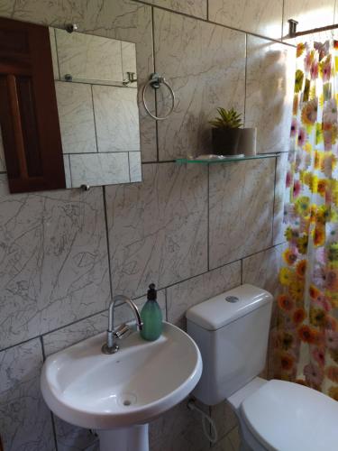 a bathroom with a white sink and a toilet at Pedra do Sol Pousada in Alter do Chao