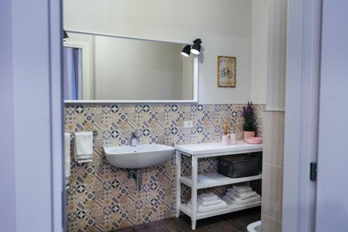 La salle de bains est pourvue d'un lavabo et d'un miroir. dans l'établissement B&B La Bicicletta, à Crémone
