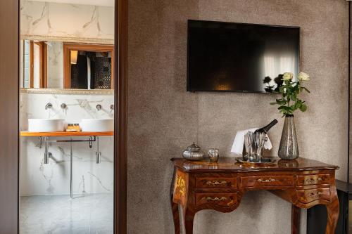 a room with a table and a television on a wall at Domus Superior in Venice