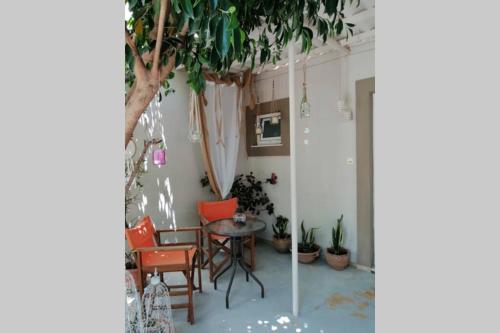 a room with a table and chairs and a tree at Beautiful House with Garden in Néa Alikarnassós