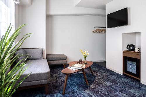ein Wohnzimmer mit einer Couch und einem Couchtisch in der Unterkunft Estinate Hotel Naha in Naha