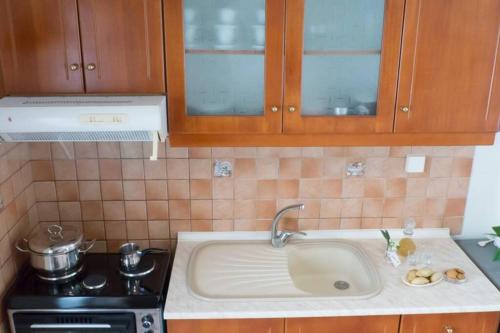 a kitchen with a sink and a stove at Beautiful House with Garden in Néa Alikarnassós