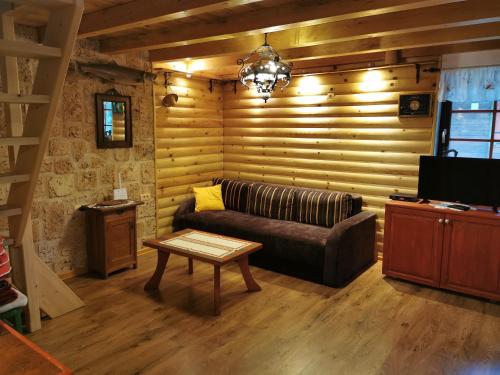 ein Wohnzimmer mit einem Sofa und einem Tisch in der Unterkunft Brvnara na obali reke Drine in Beserovina