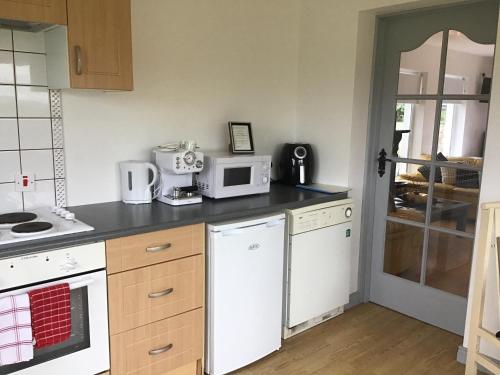 a kitchen with a stove and a microwave at Hillcrest House Self Catering Apartments in Donegal