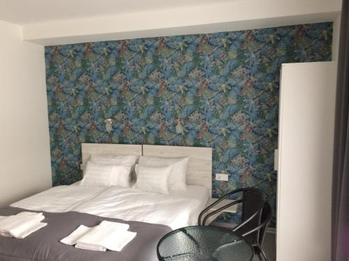 a bedroom with a bed with a floral wallpaper at Harmónia Panzió in Bogács