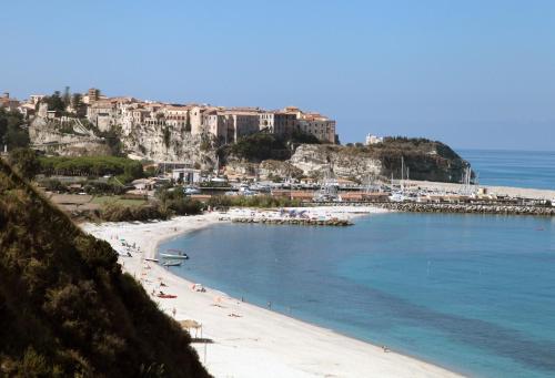 a beach with a group of people laying on the sand at Residence New Paradise in Tropea