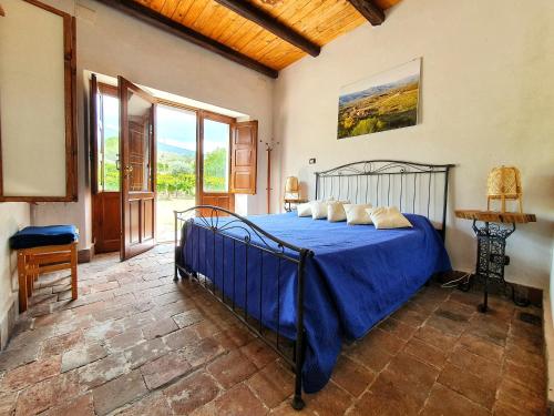 een slaapkamer met een bed met een blauwe sprei bij Suite in vigneto in Passopisciaro