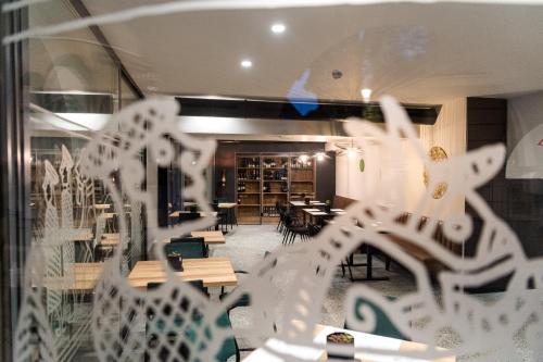 a glass window of a restaurant with tables and chairs at Hostel Situla in Novo Mesto
