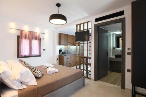 a bedroom with a bed with two stuffed animals on it at Orion Eco Suites in Karteros