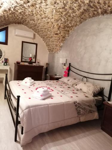 a bedroom with a large white bed with flowers on it at Antica Dimora del Drengot in Acerenza