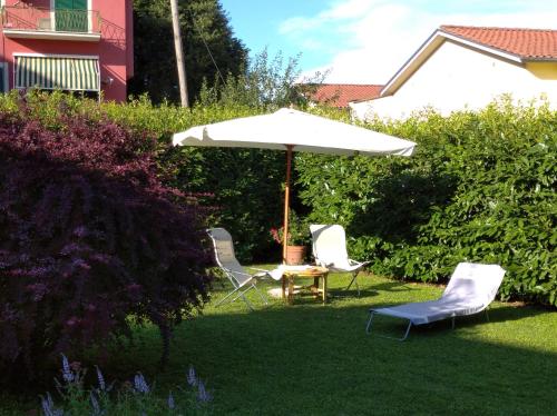 an umbrella and two chairs and a table in a yard at Il Giardino Segreto in Carbognano